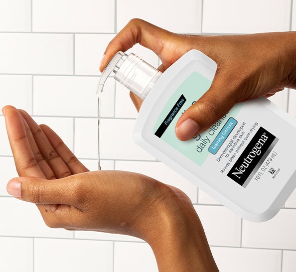 Model placing Neutrogena Cleanser in their hand for application.